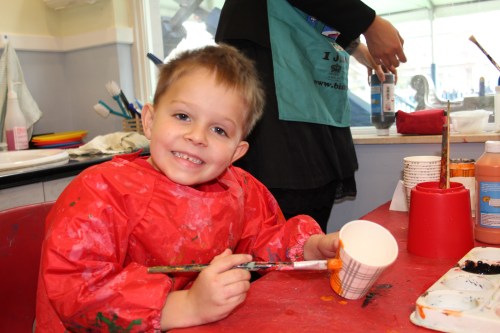 Oliver painting his trick or treat cup.