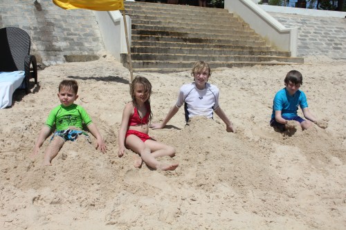 Burying each other in the sand at the beach.