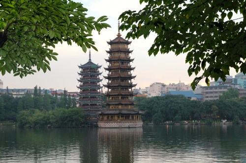 The late afternoon view of the sun and moon pagodas.  The Sun and Moon Twin Pagodas is situated in Shanhu (Shan Lake).  The word sun and moon in Chinese character written together mean brightness.  Some say it symbolises the future of Guilin is bright.  The Sun Pagoda is constructed with copper, it has 9 floors and reaches a height of 41 metres. The Moon Pagoda's is made of marble; it has 7 floors and measures 35 meters high. The two pagodas are connected via a tunnel at the bottom of the lake.