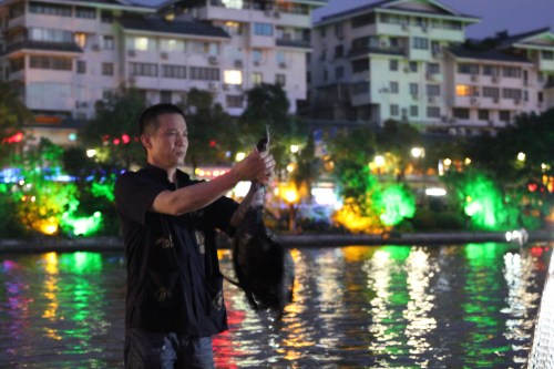 The fisherman massaging the neck to get the fish out.